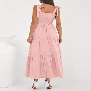 Vista trasera detallada del vestido largo rosa con volantes y elegantes tirantes para anudar.