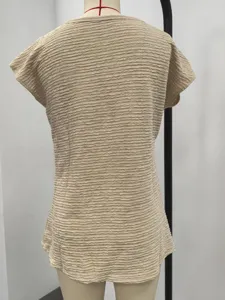 Beige gestructureerde korte top gezien van achteren, details van zomerse damesblouse.