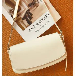 Witte leren schoudertas voor dames, stijlvolle crossbody tas met ketting en klepsluiting design.