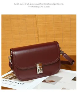 Detailed view of retro burgundy leather shoulder bag with metal lock and fine texture.