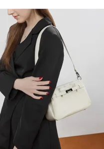 Detailed view of women's minimalist off-white shoulder bag with elegant metal turn-lock.