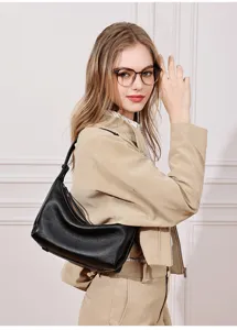 Detailed view of black leather hobo shoulder bag worn by model in professional studio shot