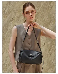 Detail view of the black leather messenger bag worn by a model in a stylish daily outfit.