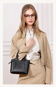 Black leather tote bag detail showing stylish design and comfortable handle grip.