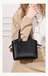 Close-up detail of the stylish black leather tote bag worn by model, showing clean design.