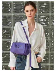 Stylish purple leather crossbody bag detail shot, featuring metal lock and adjustable strap.