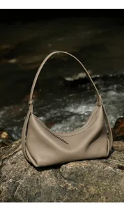 Close-up detail of the genuine leather hobo underarm bag showcased on outdoor natural rock.