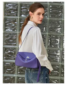 Purple leather shoulder bag detail with metal turn-lock clasp and slim strap design.