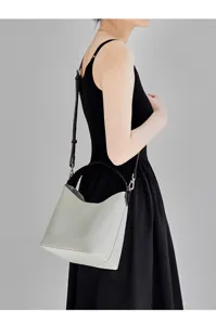 Vista dettagliata di una elegante borsa a secchiello in pelle indossata in studio.