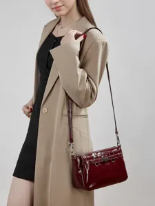 Burgundy patent leather shoulder crossbody bag worn by model, stylish daily commuter handbag.