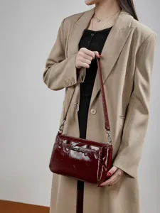 Minimalist patent leather shoulder bag for women, stylish crossbody handbag with metal lock.