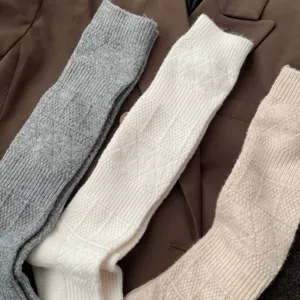 Detalle de calcetines largos de punto con patrón de rombos, mezcla de lana suave.