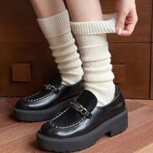 Detalle de calcetines de lana con motivo de rombos texturizado y ajuste cómodo.