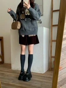Detailed view of the stylish daily OOTD featuring cozy knit sweater and long socks.