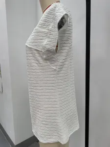 Gedetailleerd zij-aanzicht van een witte gestructureerde top met korte mouwen en stof.