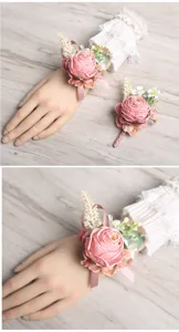 Close-up detail shot of pink artificial rose wrist flower and boutonniere for wedding decor.