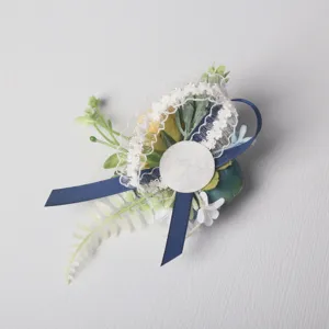 Elegant wedding boutonniere corsage with artificial flowers, lace, and blue ribbon for formal events.