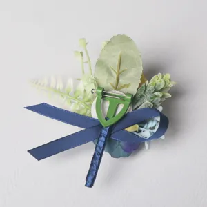 Detailed view of the back of a wedding boutonniere with secure pin and blue ribbon wrap.