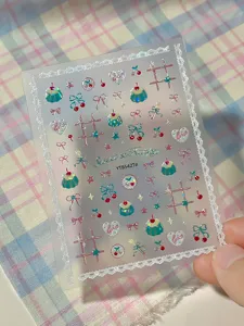 Close-up detail of cute cherry and pudding nail stickers featuring sweet lace and lovely bow designs.