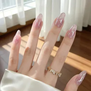 Uñas postizas ovaladas largas con degradado rosa y diseño de estrellas plateadas chic.