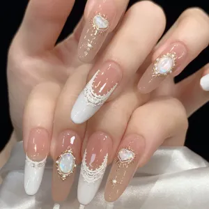 Vista detallada de uñas postizas barrocas de encaje vintage en relieve con gemas.