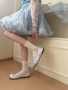 Gedetailleerde opname van zoete kant-sokken met zilveren ballerina's, zachte stijl.