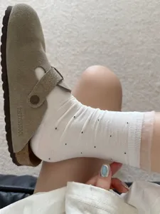 Vue détaillée de chaussettes mi-hautes à pois en dentelle d'organza transparente avec sabots.