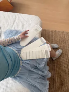 Detailopname van Koreaanse stijl wit-grijze zijden compressiesokken met kanten details.
