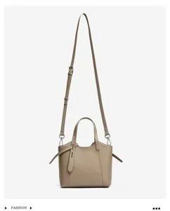 Genuine leather minimalist bucket tote bag with top handles and adjustable crossbody strap.