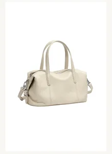 Gedetailleerd overzicht van de beige leren Boston tas met zachte textuur en metalen rits.