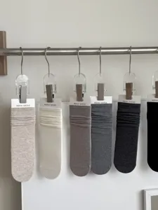 Detail view of solid color pure cotton slouch socks, minimalist early autumn style.