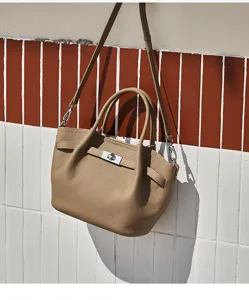 Vista dettagliata di un'elegante borsa in pelle beige con chiusura a girello e cinturini.