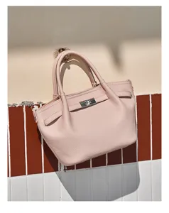 Dettaglio borsa rosa in pelle strutturata, elegante chiusura metallica a girello e finiture curate.