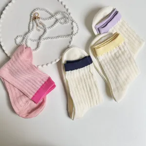 Close-up detail view of casual women mid-tube socks with contrast colorful ribbed cuffs and hollow knit.