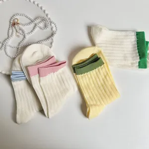 Detailed view of women knit mid-tube socks with contrast color cuffs, cute daily style.