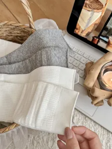 Detailed shot of women's ribbed crew socks in white and grey, cozy lifestyle display.