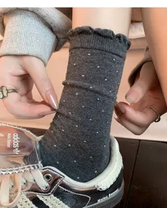 Dark grey crew socks with cute ruffles and white dot pattern, comfortable cotton blend for women.