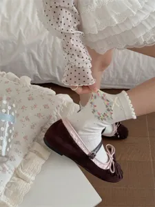 Close-up detail shot of sweet Korean style floral bow mid-calf socks paired with vintage mary janes.