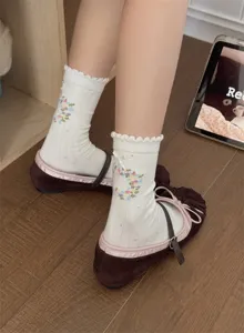 Close-up detail of sweet floral embroidery lace bow white mid-calf socks for women.