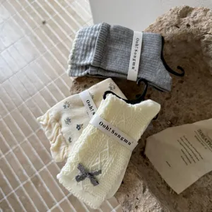 Korean style cute floral stacked socks detailed close-up, soft knit fabric design.
