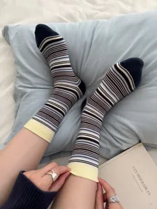 Detail shot of vintage striped mid-calf socks with color-block design and yellow cuffs.