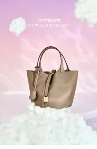 Vue détaillée d'un sac seau élégant en cuir avec fermoir cadenas et poignées, look premium.