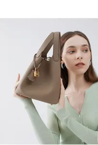 Vue détaillée d'un sac seau en cuir gris avec fermoir métallique et doubles poignées.