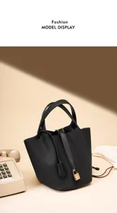 Vue de détail du sac seau en cuir noir de luxe avec cadenas doré et poignées élégantes.