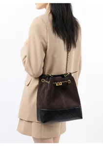 Dettaglio borsa secchiello catena in pelle scamosciata, elegante borsa tracolla.