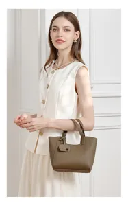 Detail view of stylish large capacity leather tote bag in taupe with cute elephant charm.