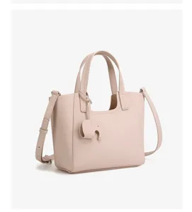 Detailed view of the chic leather tote bag featuring a cute elephant charm and handles.