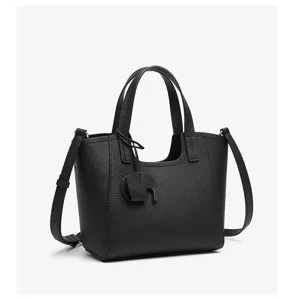 Black pebble leather tote bag with top handles and cute charm for women casual daily use.