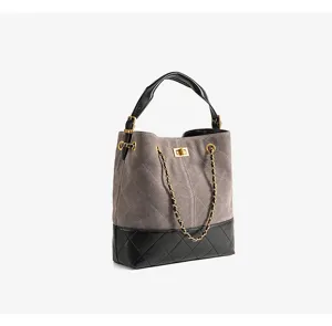 Borsa a secchiello in camoscio grigio e pelle nera con tracolla a catena e dettaglio.