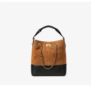 Borsa a secchiello classica in camoscio marrone e pelle nera con tracolla a catena e chiusura.